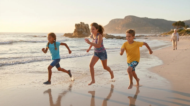 Children running along a beach, moving freely and playing without structured sport