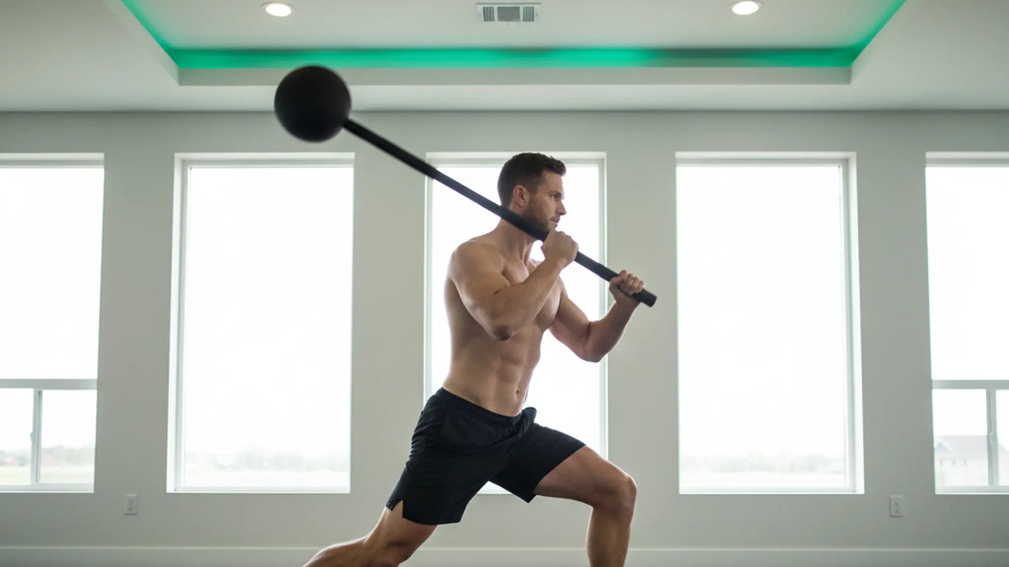 Man performing dynamic macebell swing for rotational strength and shoulder mobility training