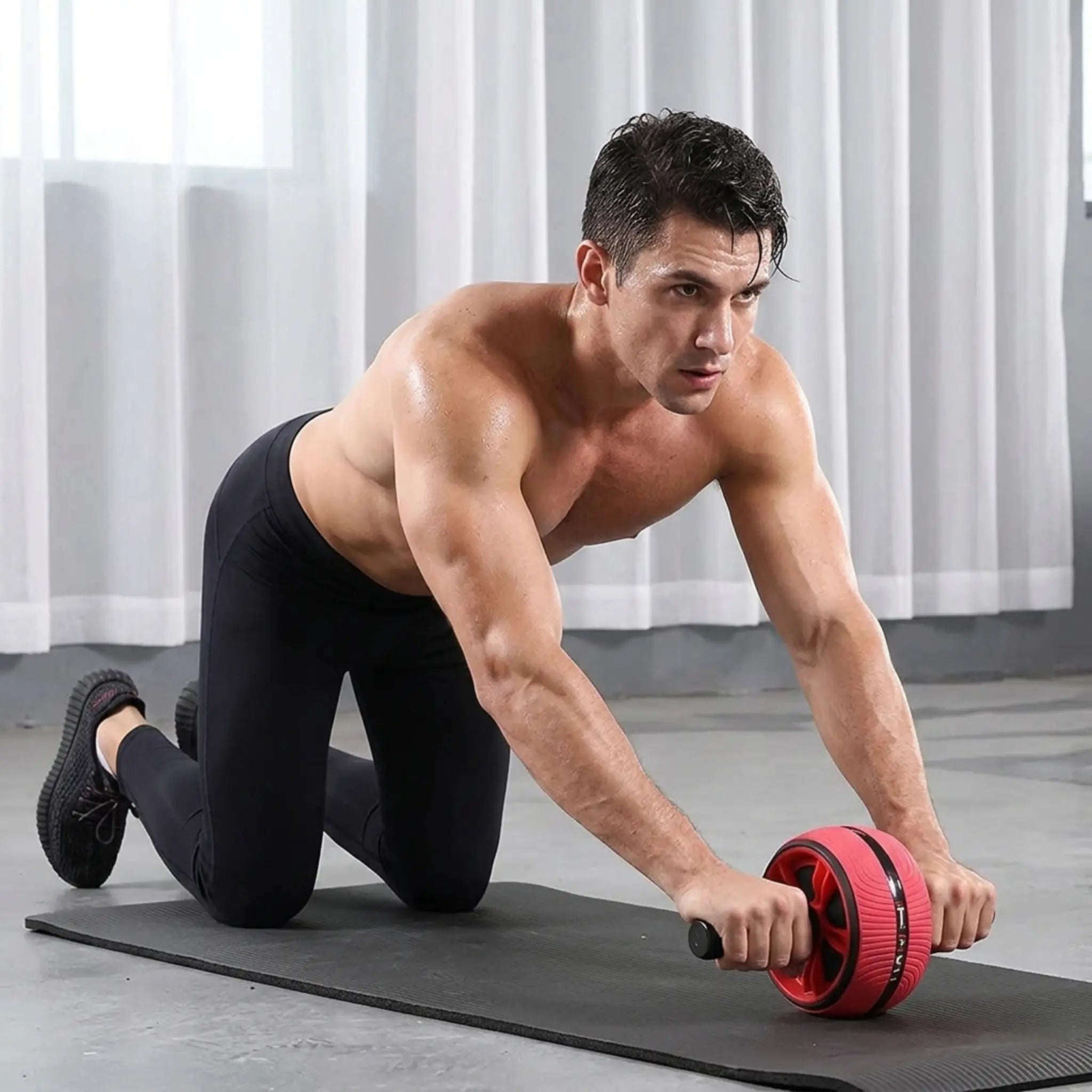 Person performing an ab wheel rollout exercise on the included knee mat