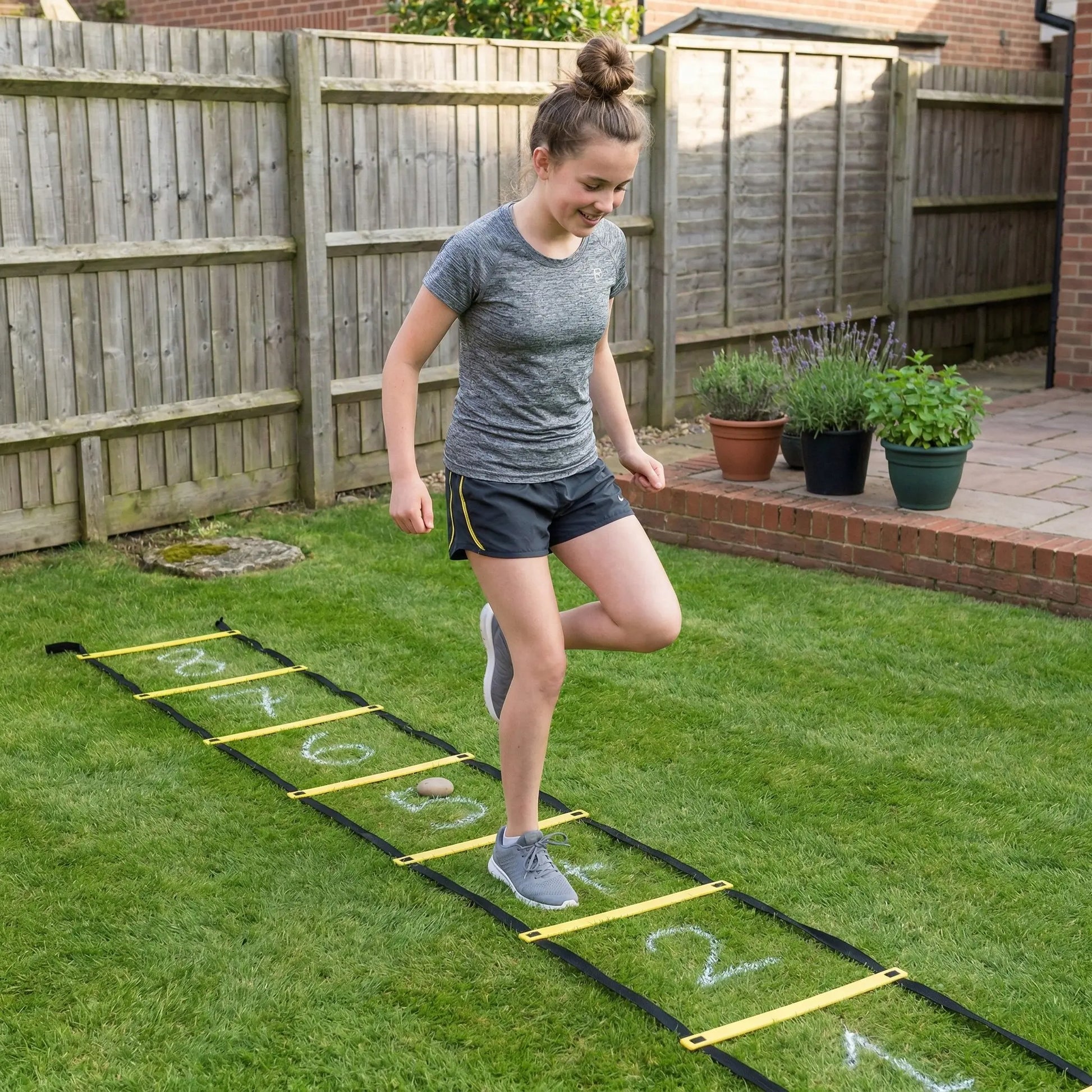 Girl doing agility ladder drill in garden