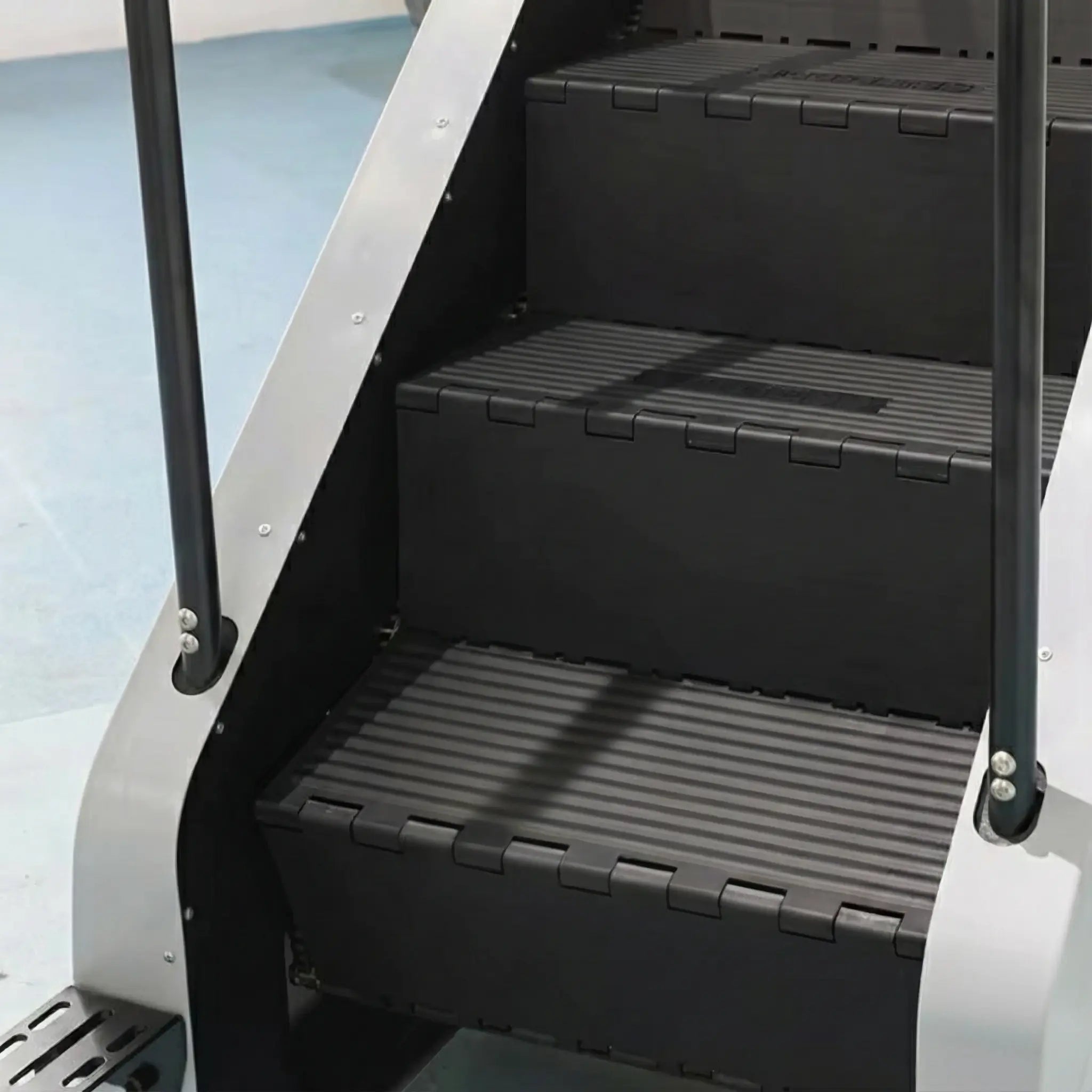 Stair climber detail shot focussing on non-slip steps and safety handrails