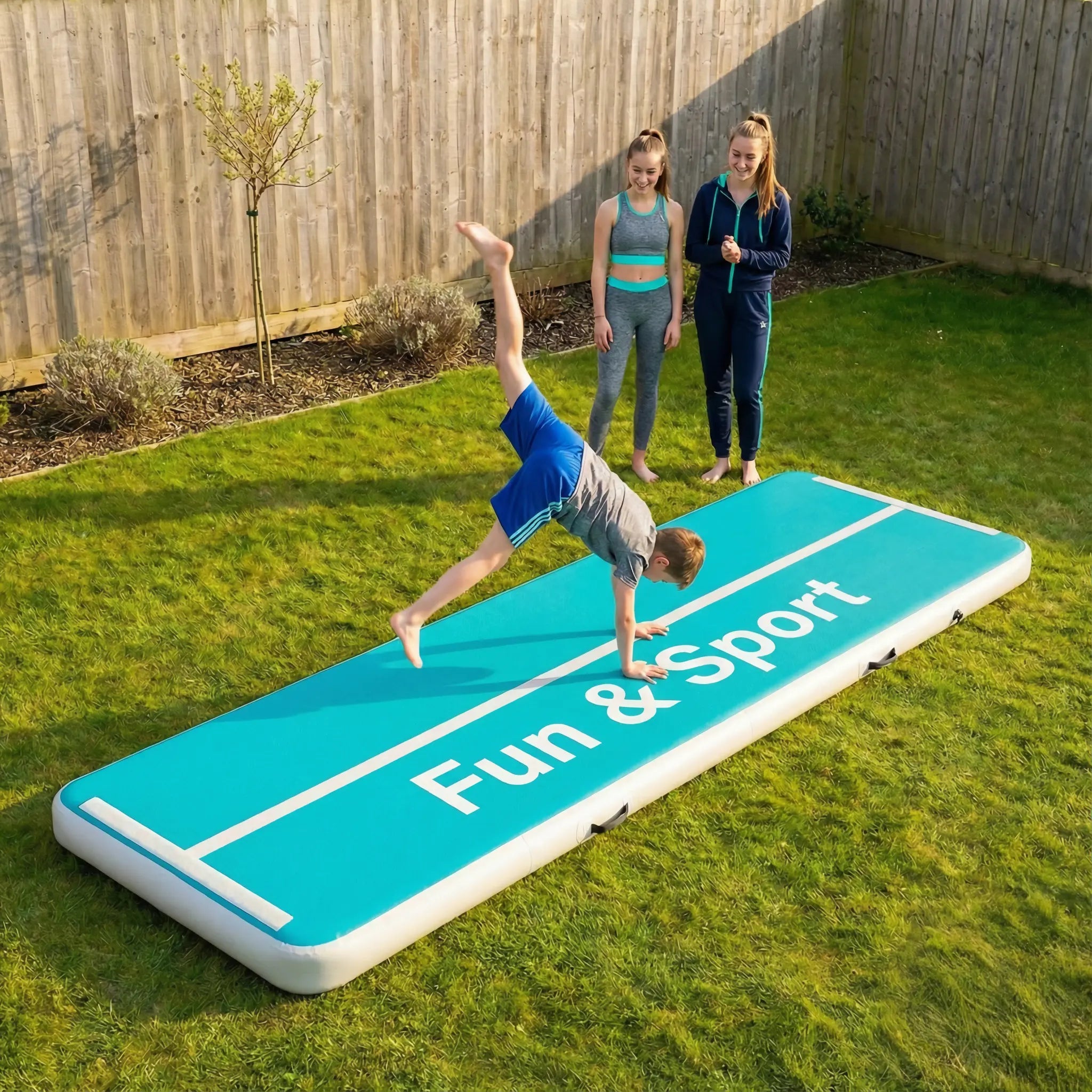 Kids practising flips on a Fun & Sport air track in the garden during active outdoor play.