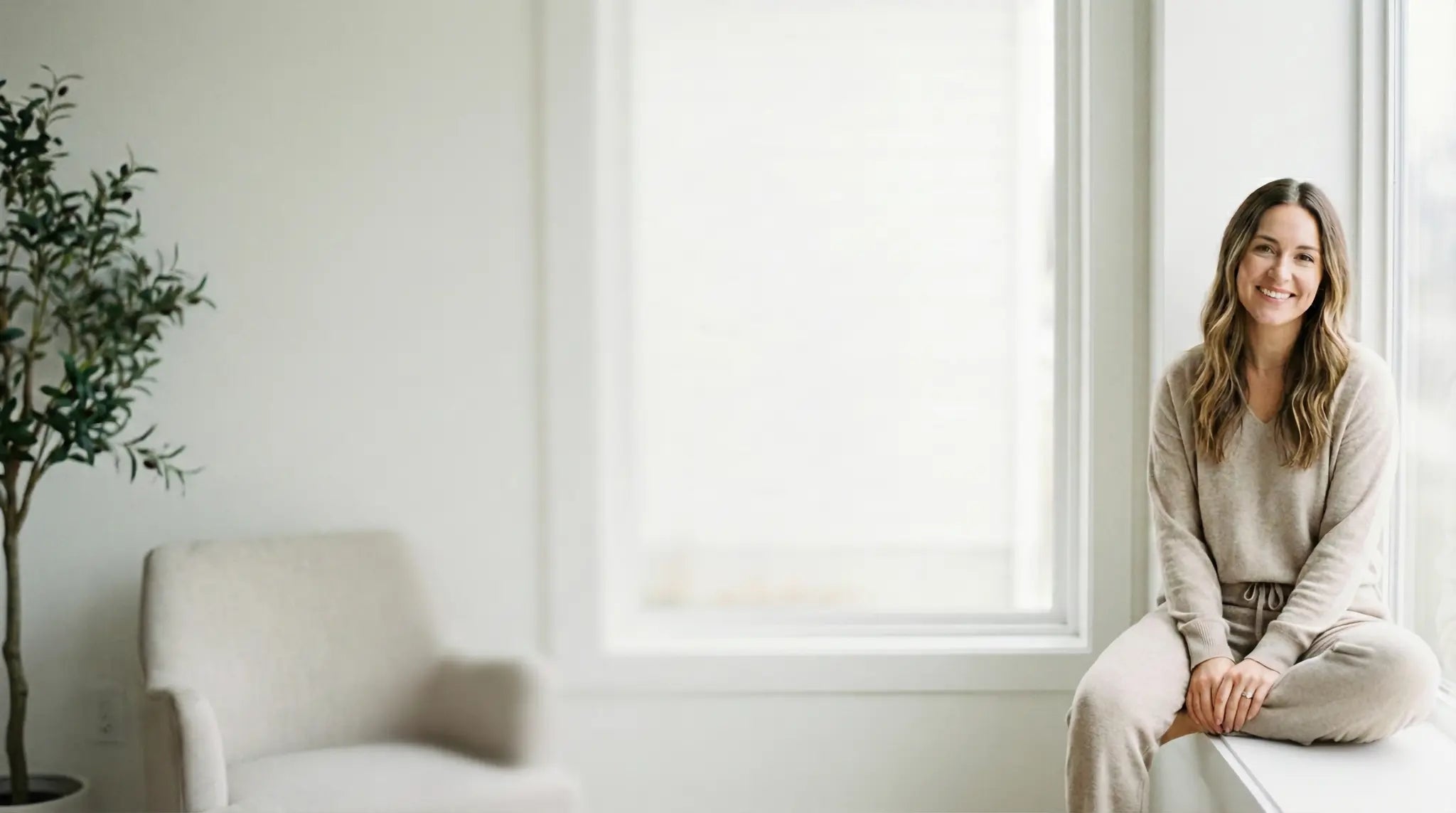Friendly woman in loungewear sitting in a bright home, representing the Fun & Sport customer support team ready to answer questions about fitness gear.