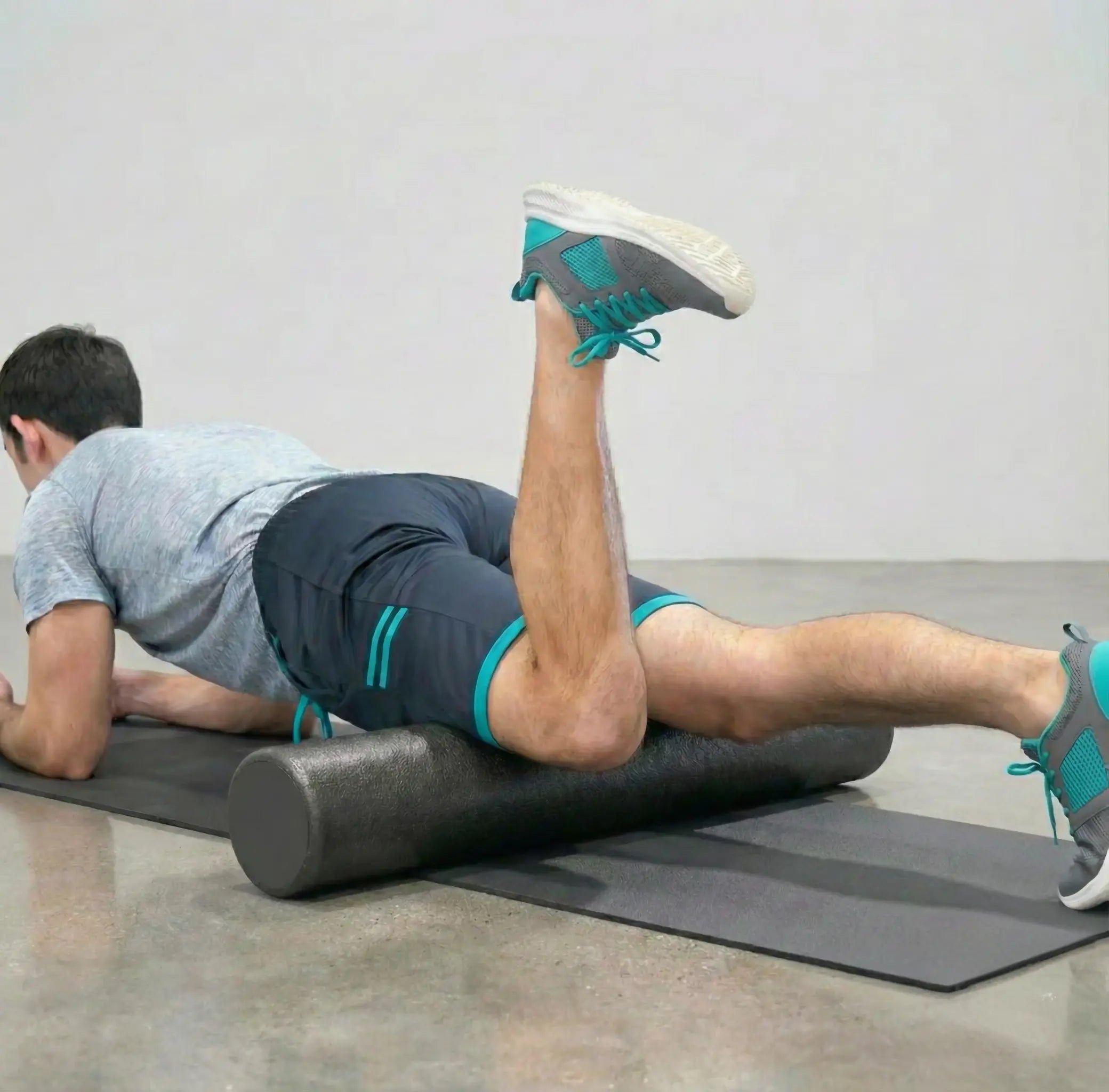 Man using a high-density foam roller to release tension in his quadriceps.