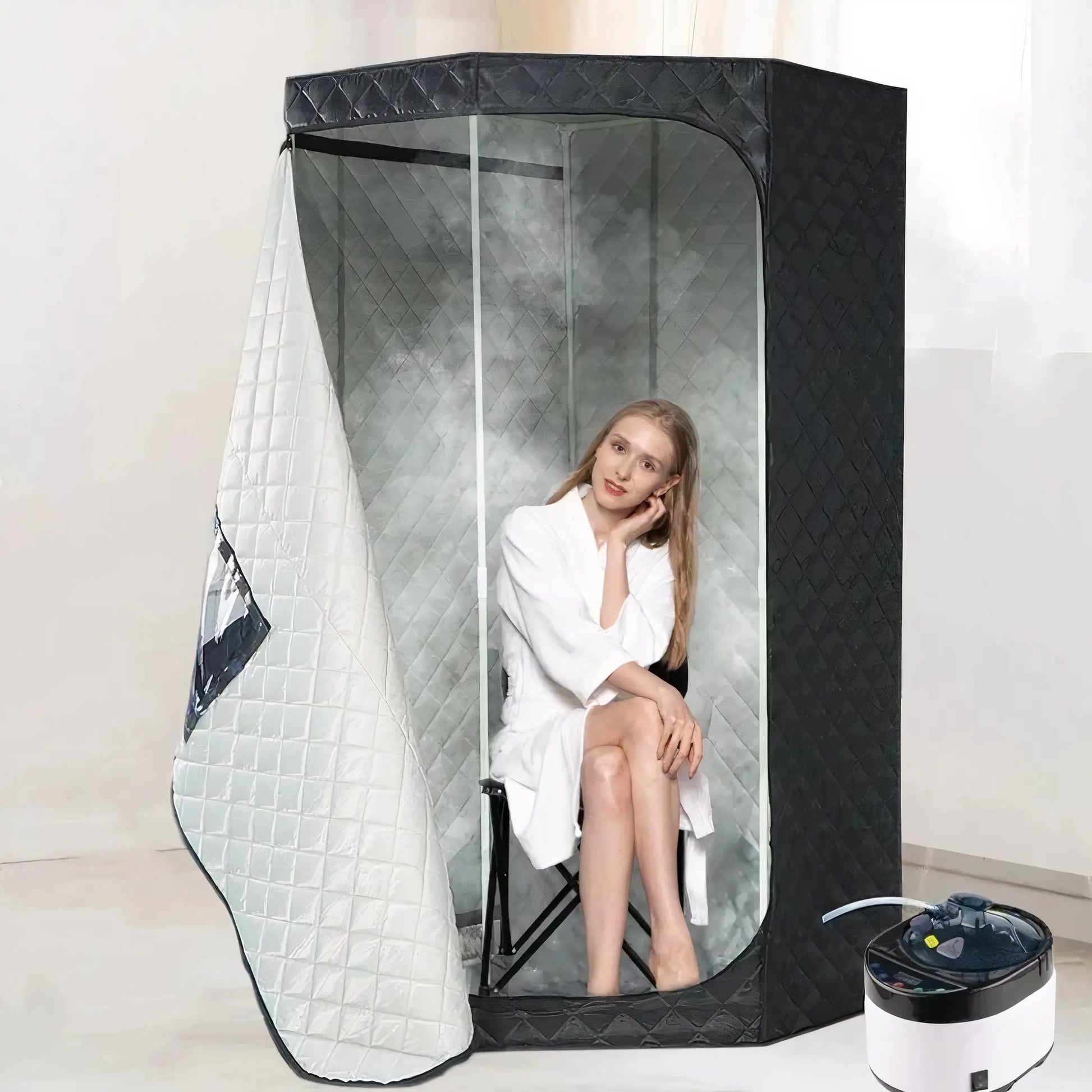 Person sitting inside a black and clear steam sauna tent