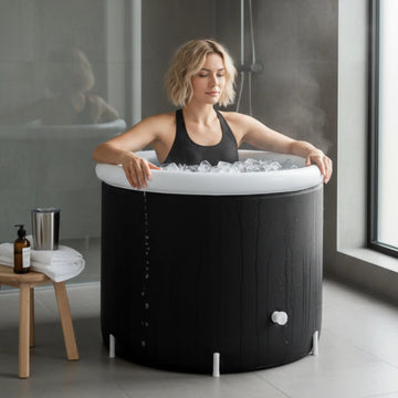 Woman using insulated portable ice bath indoors for cold plunge recovery