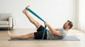 Man stretching with a resistance band on a yoga mat in a living room.