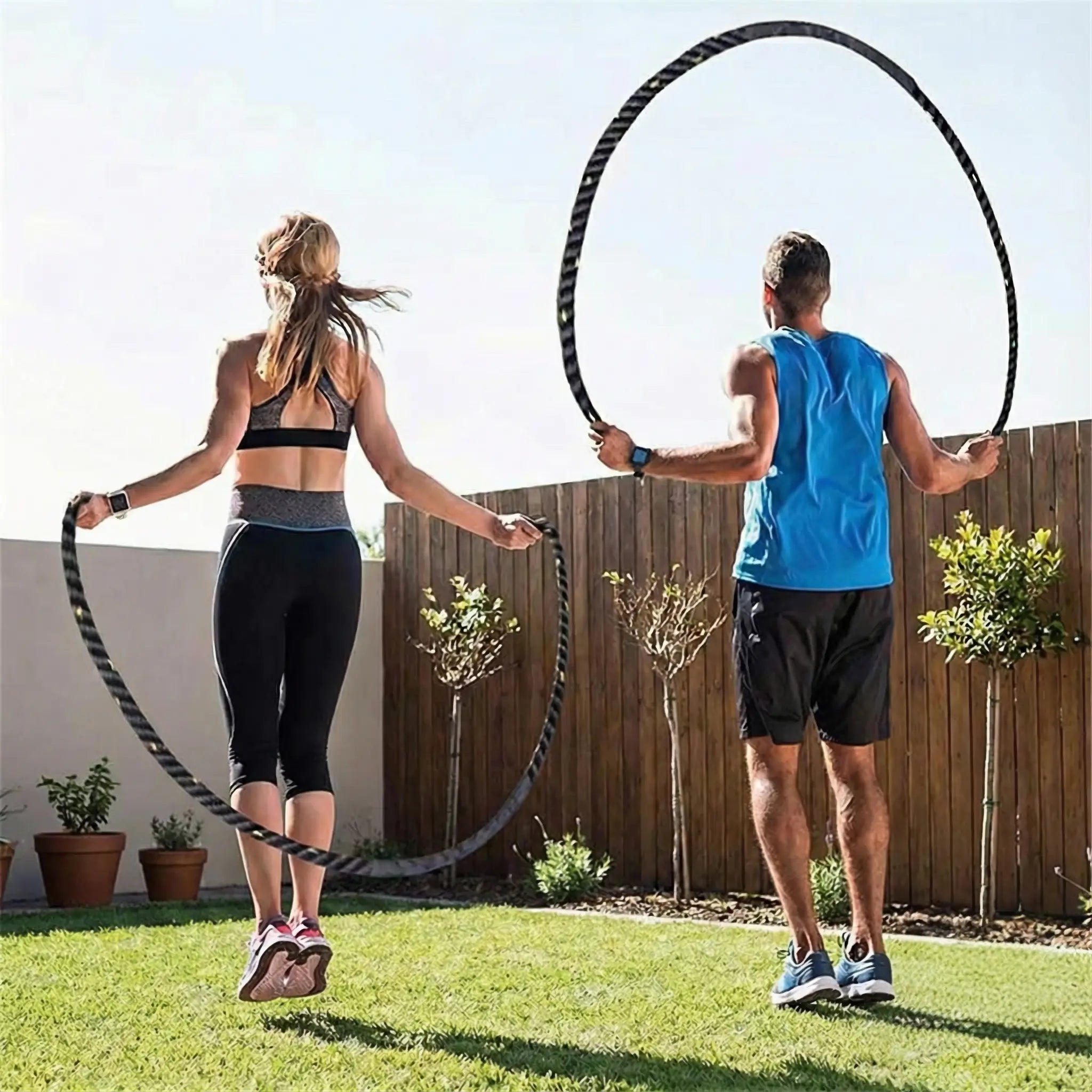 Two people using weighted skipping ropes in a garden.